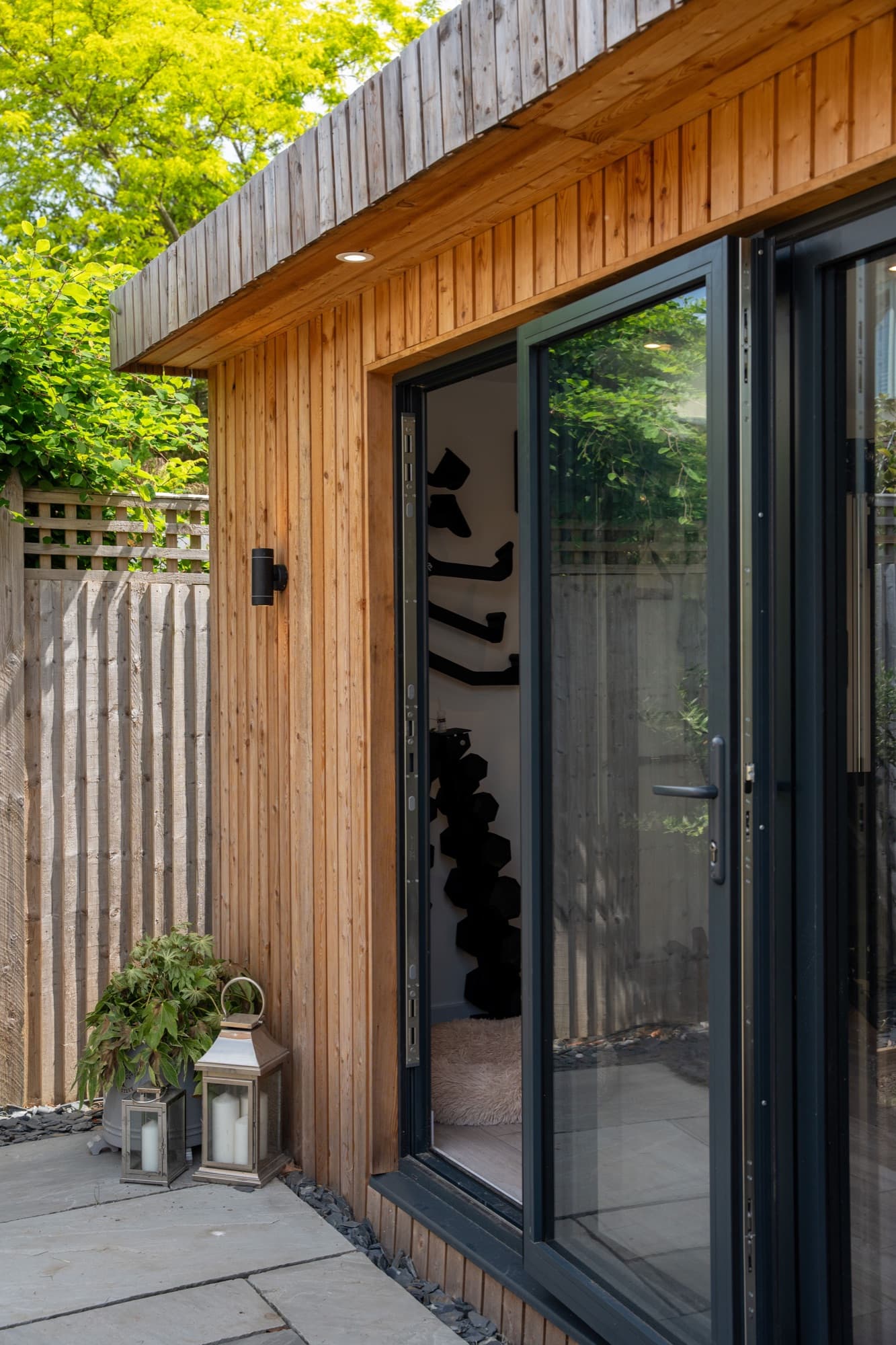 Detail of aluminium bifold doors against vertical timber cladding