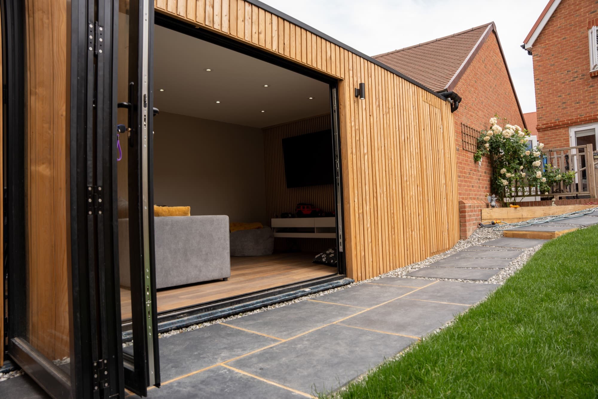 Garden lounge with corner bifold doors folded fully open onto a patio